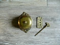 an antique brass plate with two handles and a door handle on a wooden table top