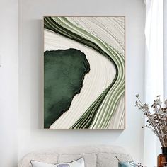 a living room with a white couch and green art work on the wall above it