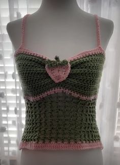 a crocheted top is displayed on a mannequin