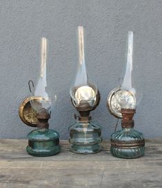 three glass vases sitting on top of a wooden table