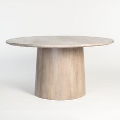 a round wooden table sitting on top of a white floor