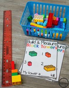 a ruler and some legos are on the table next to a building block tower