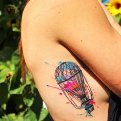 a hot air balloon tattoo on the back of a woman's left upper arm