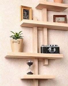 three wooden shelves with plants and pictures on them, one has a camera in it