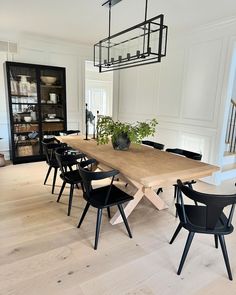 a dining room table with black chairs and a potted plant