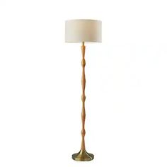 a floor lamp with a white shade on the base and a gold colored metal pole