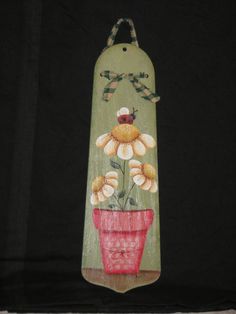 this is an image of a vase with flowers painted on the side and hanging from it