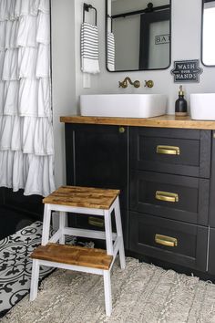 a black and white bathroom with wooden stools