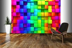 a chair sitting in front of a multicolored wall with a potted plant