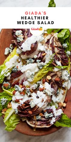 a salad with lettuce, cheese and nuts in it on a wooden platter