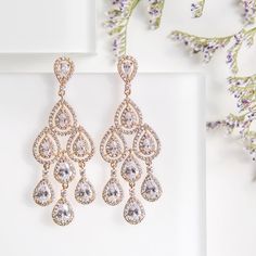 Cubic Zirconia crystal bezels nestle within pavé-framed teardrops in super-glamorous chandelier earrings that will sparkle at every angle. Complete your look with wildly romantic loose side-swept bun. Available in: 18K White Gold / Gold / Rose Gold over base metal Cubic Zirconia pave crystals Hypoallergenic post Height: 2.25in (5.7cm) x Width: 0.6in (1.6cm) #E147 Chandelier Earrings Wedding, Gold Earrings Bridal, Chandelier Earrings Gold, Teardrop Chandelier, Silver Bridal Jewellery, Wedding Earrings Chandelier, Dangle Earrings Wedding, Gold Chandelier Earrings, Gold Bridal Earrings