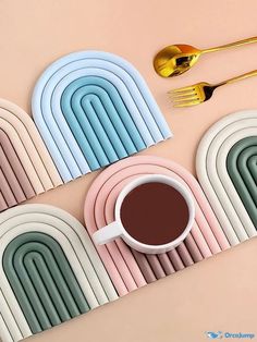 four different colored plates with gold forks and spoons next to each other on a pink surface