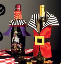 two wine bottles are decorated as jack - o'- lanterns and one is holding a bottle of booze