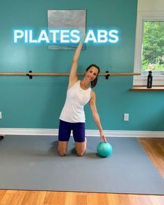 a woman is doing pilates abs with a blue ball in front of her