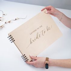 two hands holding a notebook with the words letters to the bride on it