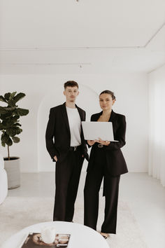 a man and woman standing next to each other in a room with white carpeting