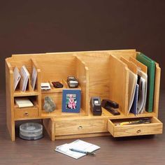 a wooden desk with several compartments and papers on it, including an open file cabinet