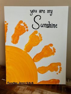 a hand and foot print with the words you are my sunshine painted on it in orange