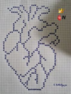 a cross - stitch pattern is shown on a piece of paper that has been made into an ornament