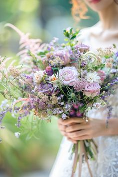 a woman holding a bouquet of flowers in her hands