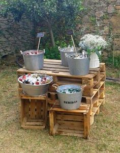 several buckets are stacked on top of wooden pallets with flowers in the middle