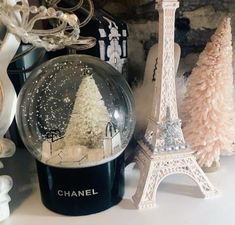 a snow globe sitting on top of a table next to a christmas tree and other decorations