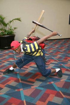 a man with a baseball bat and backpack on his back is running across the floor