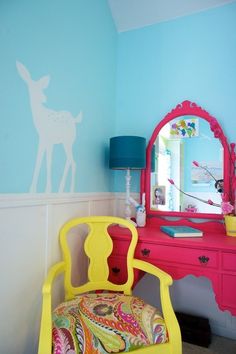 a room with a chair, mirror and deer decal on the wall