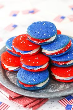 red, white and blue cookies stacked on top of each other in front of an american flag table cloth