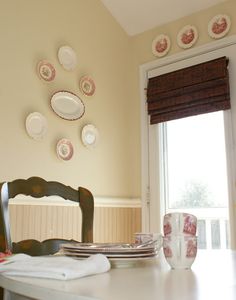 a dining room table with plates on the wall