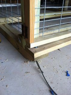 a close up of the side of a building with wire and wood on the ground