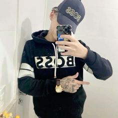 a man taking a selfie in front of a mirror wearing a boss hoodie