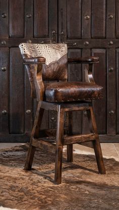 an old wooden chair sitting in front of a wall with wood paneling and leather upholstered seat