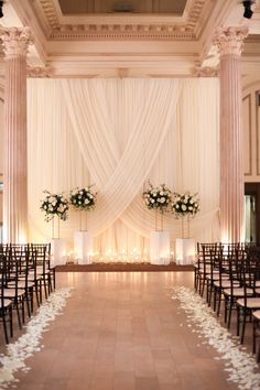 the aisle is decorated with white flowers and candles