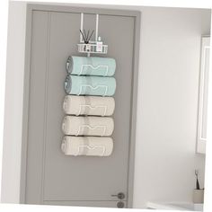 four folded towels are hanging on the wall next to a door with a towel rack