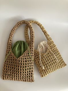 two crocheted purses sitting next to each other on a white table top