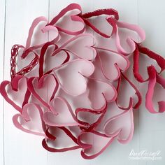 pink and red paper hearts on white background