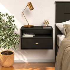 a bedroom with a bed, nightstand and plant on the side table next to it