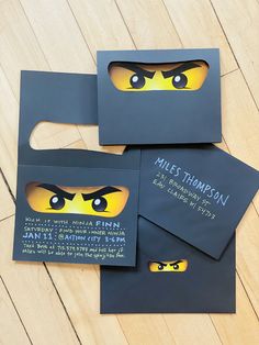 three black envelopes with yellow eyes on them