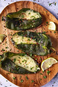 stuffed jalapenos on a wooden cutting board with limes and seasoning