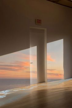 an open door leading to the ocean at sunset