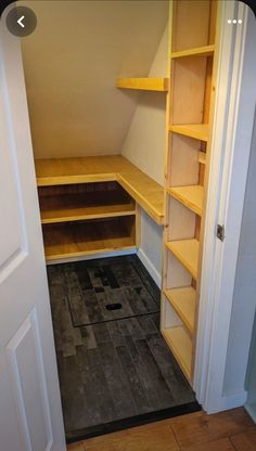 an empty walk in closet with shelves and tile flooring