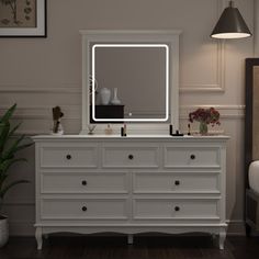 a white dresser with a large mirror on it