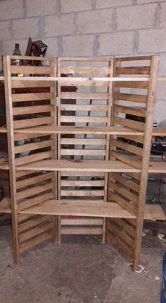 a large wooden shelf sitting in the middle of a room next to a brick wall