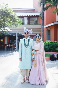 two people standing next to each other in front of a building