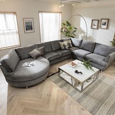 a living room with grey couches and white coffee table