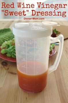 red wine vinegar and sweet dressing in a blender on a table with lettuce