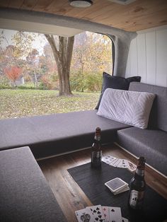 a couch and table in a room with a large window looking out onto the field