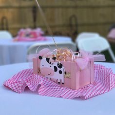 a pink box with a cow on it sitting on top of a white table cloth