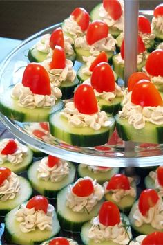 cucumbers with tomatoes and cream cheese are arranged on a platter to serve as appetizers